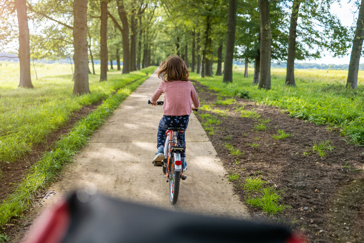 Zes rennende kinderen met rugzak op, gezien van achteren